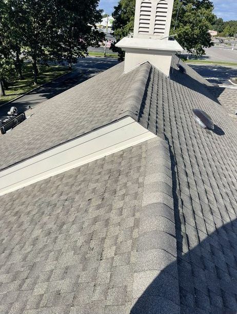 A close up of a roof with a chimney on top of it.