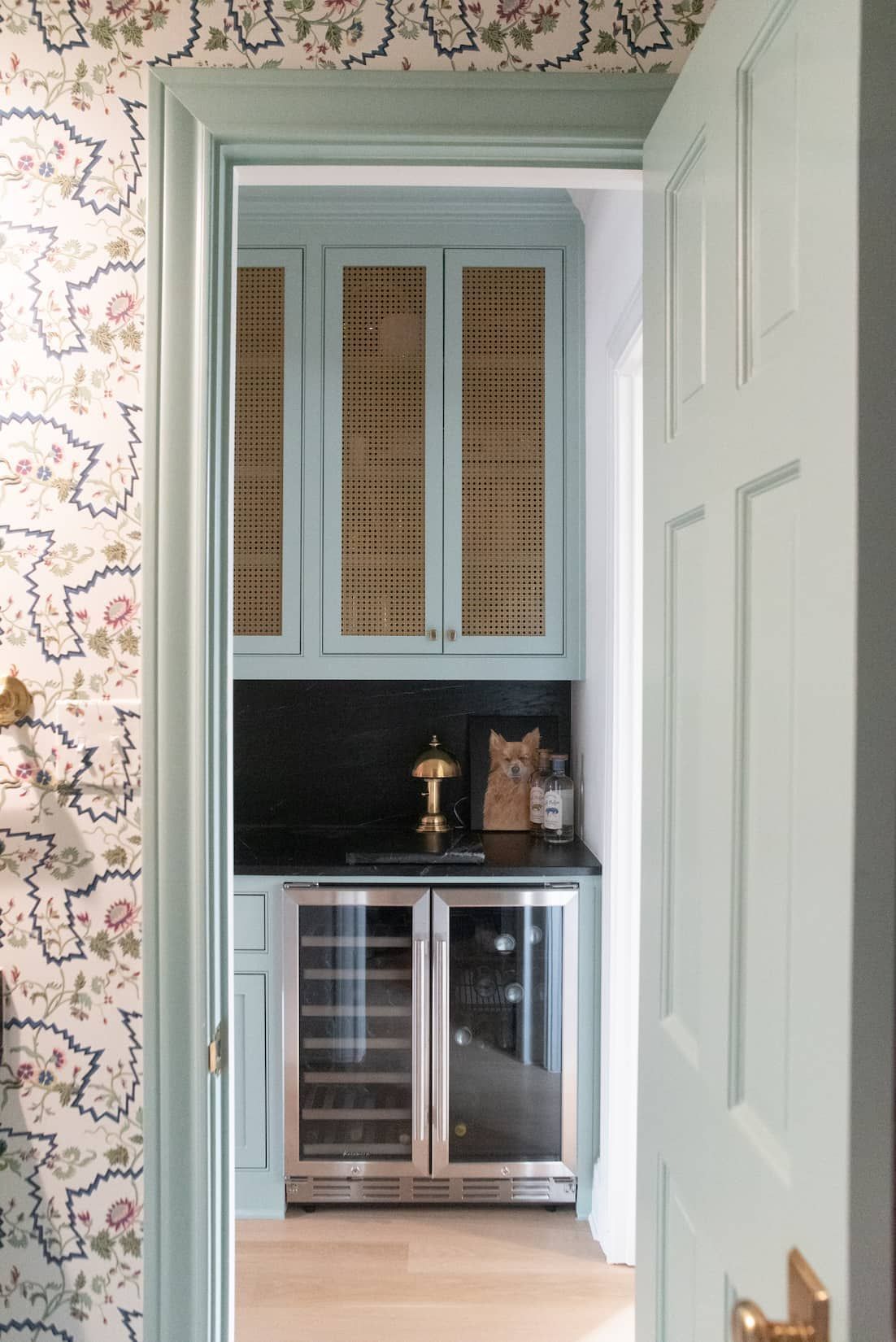 A kitchen with blue cabinets and a stainless steel wine refrigerator