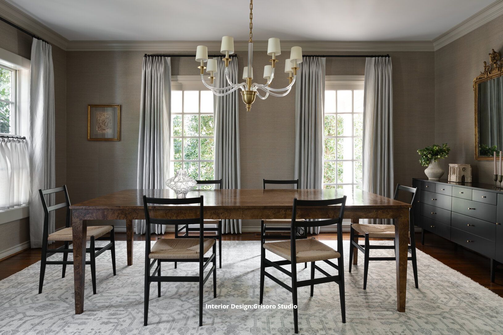 A dining room with a table and chairs and a chandelier.