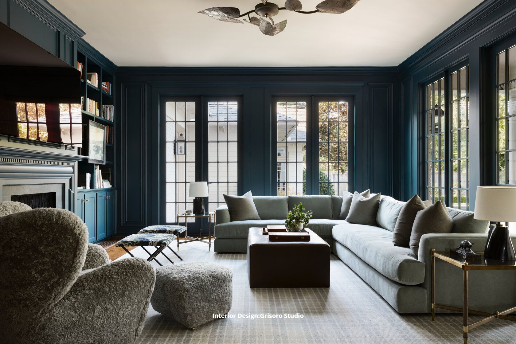 A living room with a large sectional couch , chairs , coffee table and fireplace.