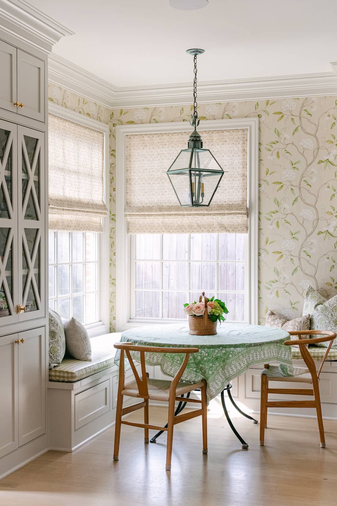 A breakfast nook with a table and chairs in front of a window.