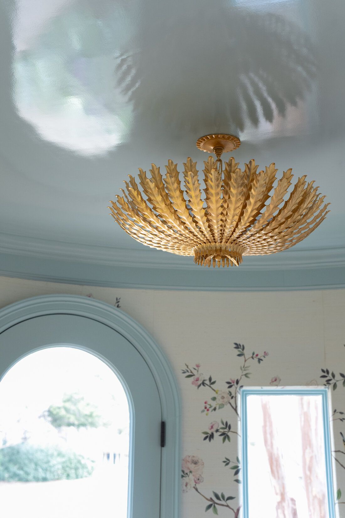 A gold chandelier is hanging from the ceiling of a room.