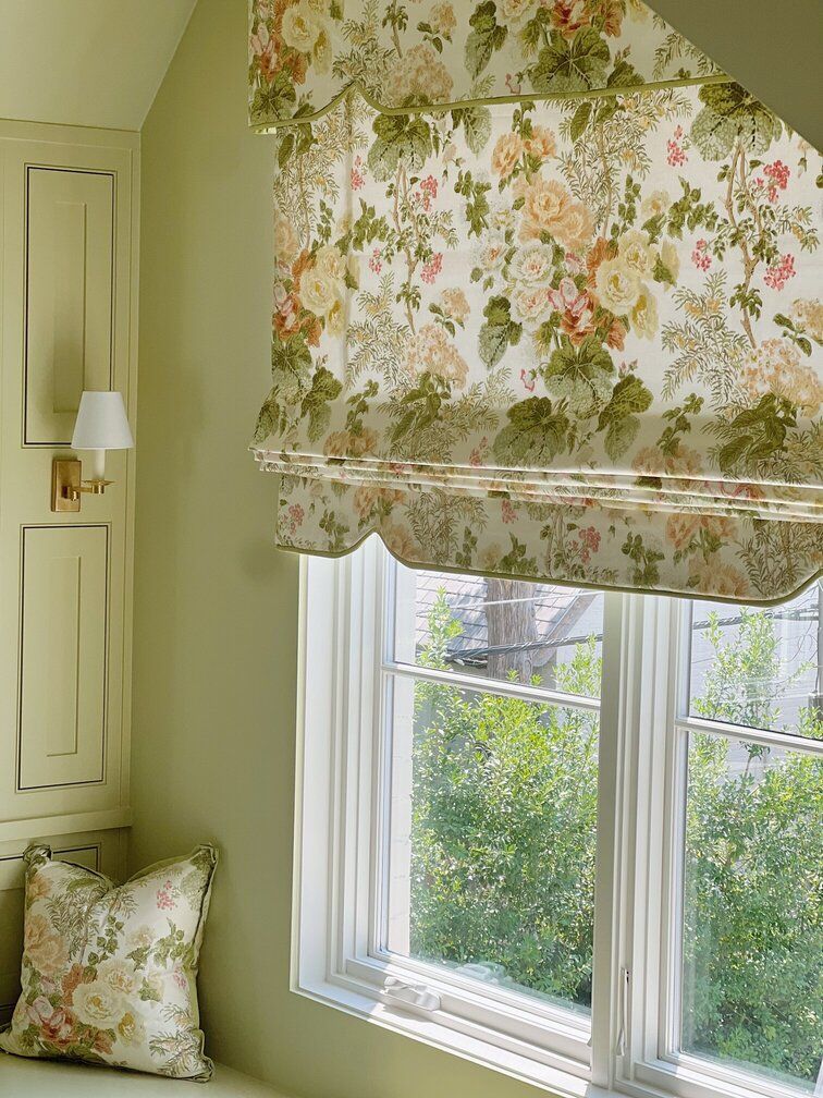 A window with a floral roman shade on it