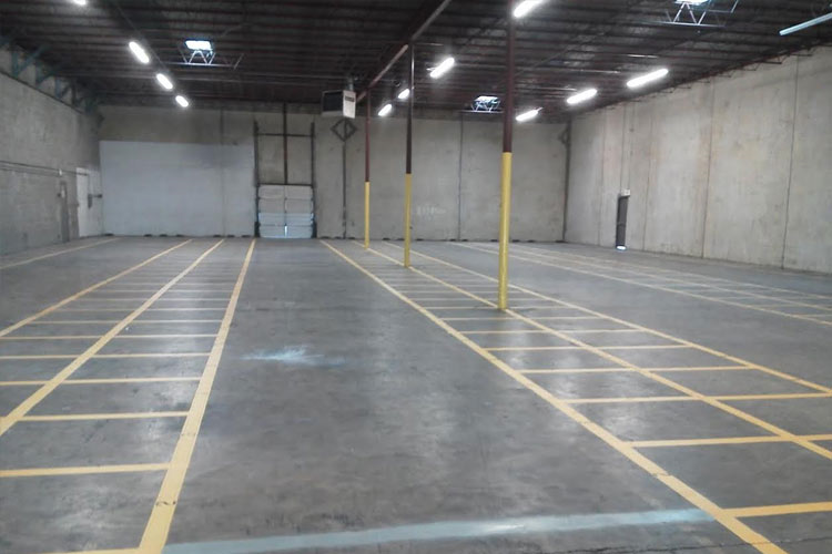 An empty warehouse with yellow lines on the floor