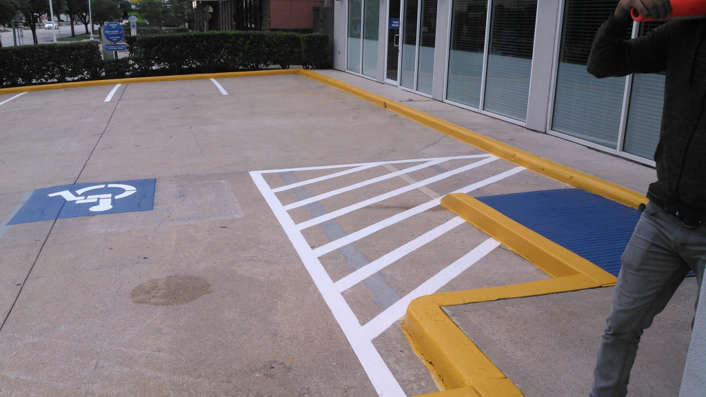 A man is standing next to a handicapped parking space