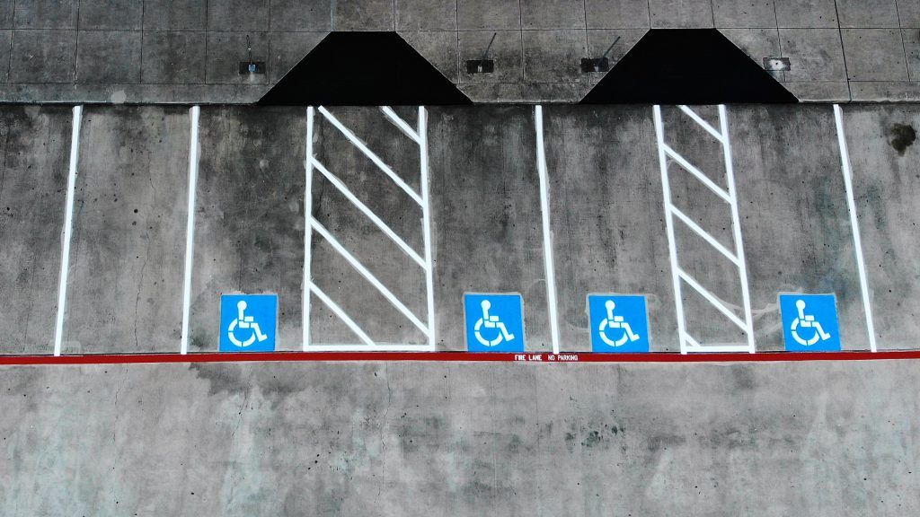 A row of handicapped parking spaces painted on a concrete wall