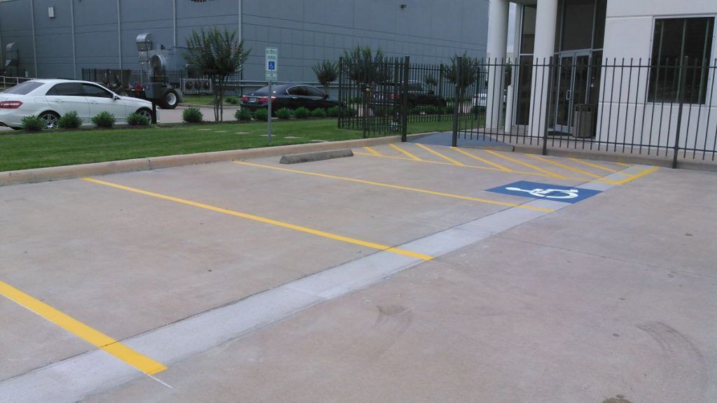 A white car is parked in a handicapped parking spot