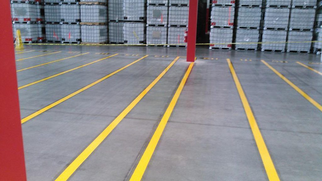 A large warehouse with yellow lines on the floor.