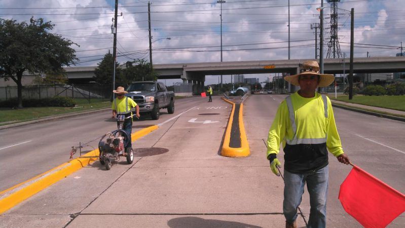 A man in a yellow shirt is holding a red flag