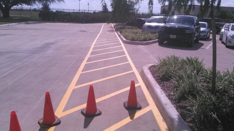 A parking lot with yellow lines and orange cones