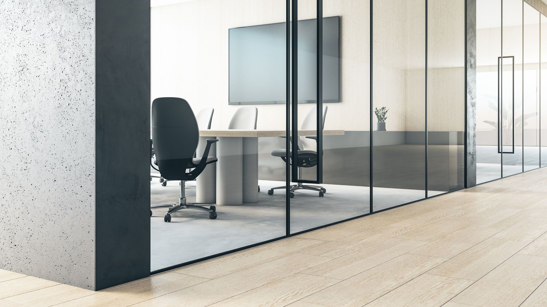 A conference room with a table and chairs and a television on the wall.