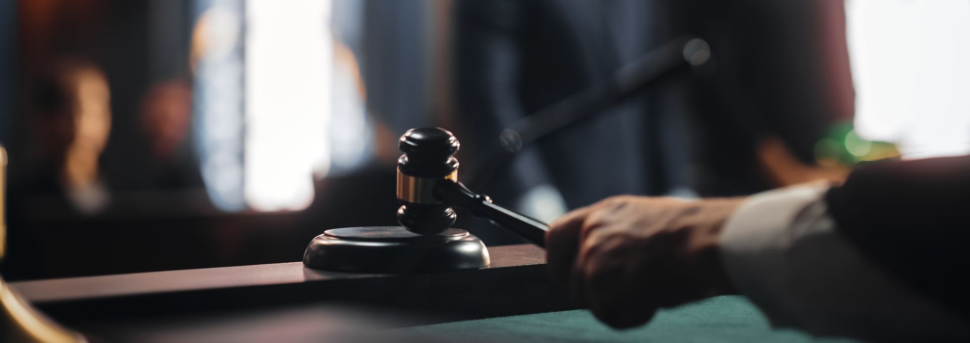A judge is holding a gavel in a courtroom.