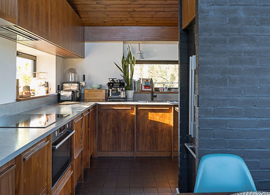 A kitchen with wooden cabinets and stainless steel counter tops.