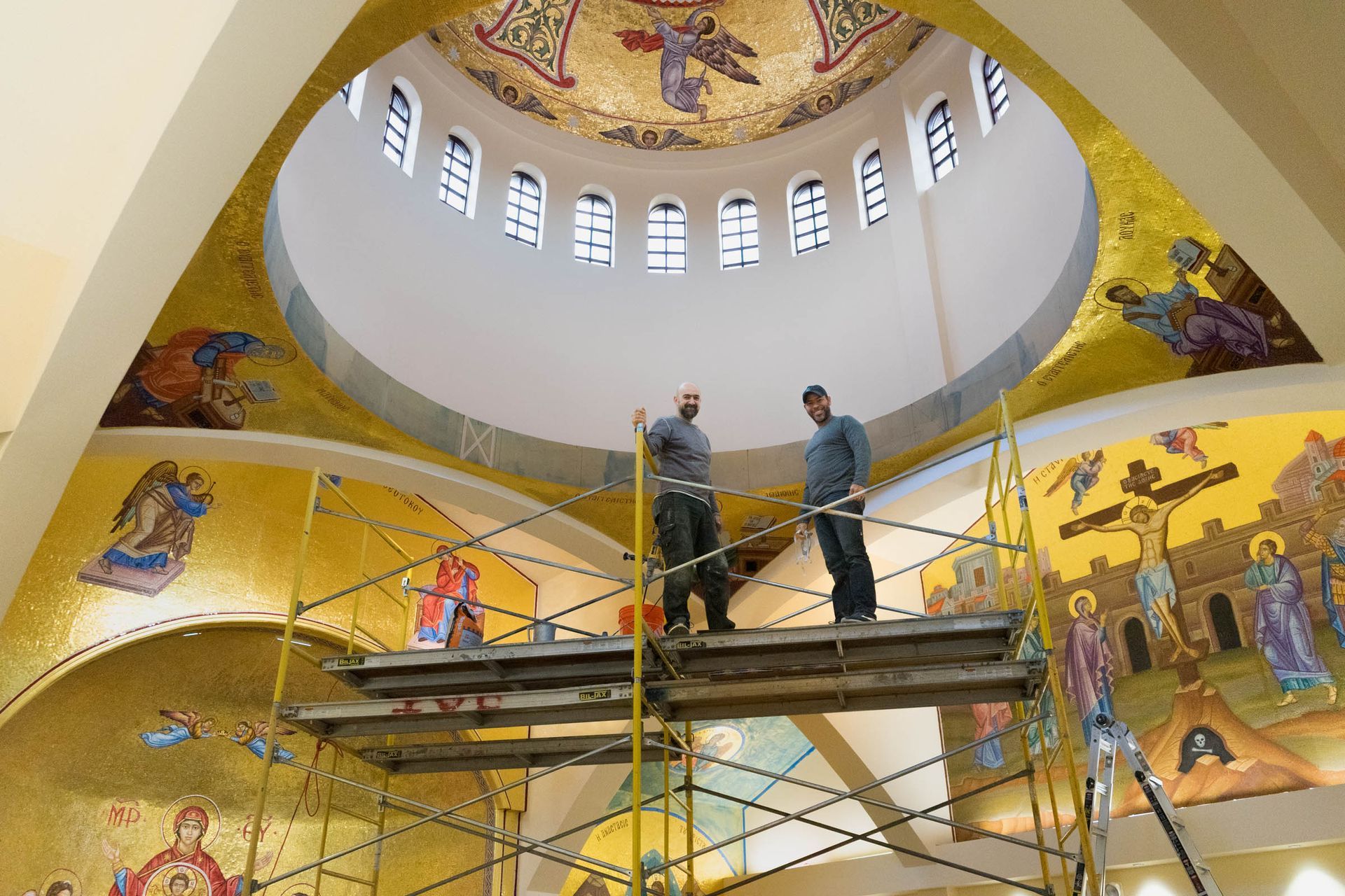 Artisans on scaffolding prepping wall for installation of Orthodox church mural mosaic wall panels at Denver Cathedral chapel