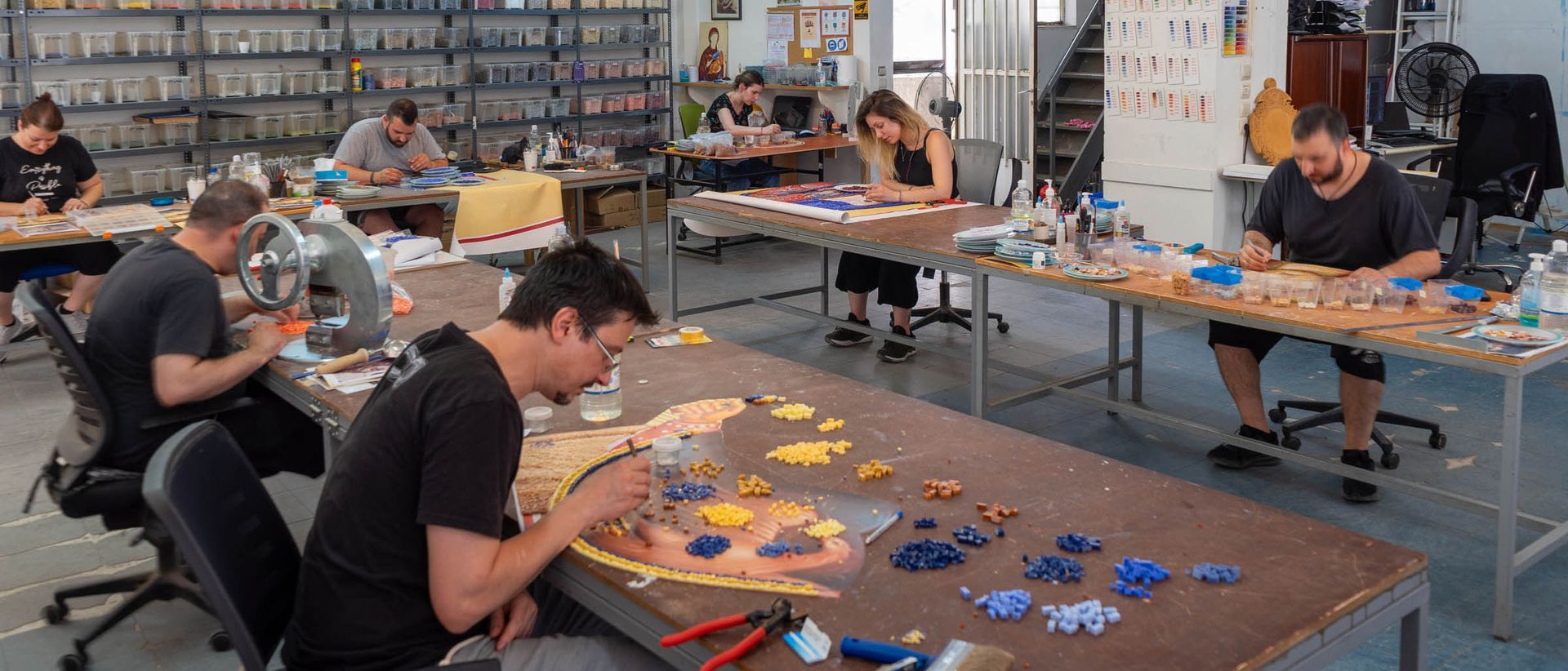 Byzanine Artworks studio artisans hand-cut and lay mosaic tesserae in our workshop in Greece during church mosaic fabrication