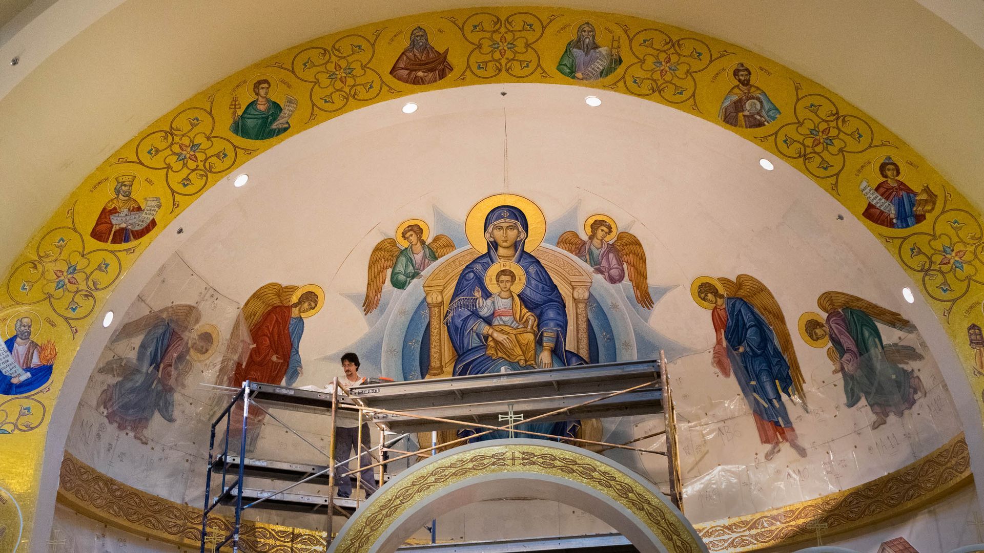 Orthodox apse mosaic installation with scaffolding. Platytera mosaic being installed by artisan at Greek church in Weston, MA
