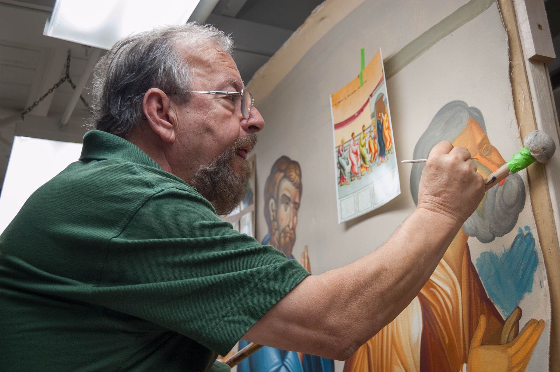 Iconographer George Papastamatiou painting large Communion of the Apostles mural for Orthodox and Eastern Christian churches.