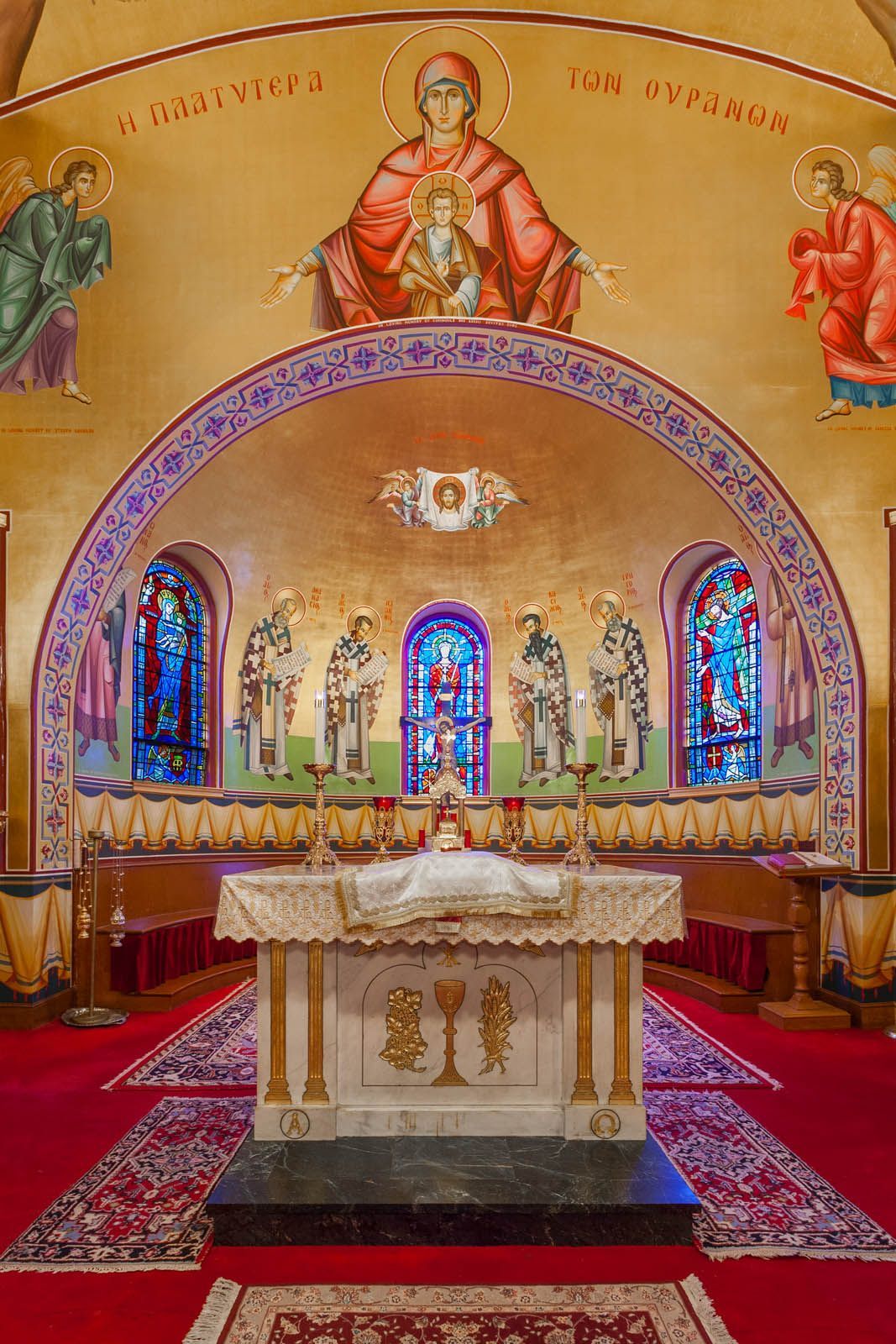 Orthodox apse mural Platytera and gold-leaf iconography behind Altar, hand-painted church fresco by Byzantine iconographers