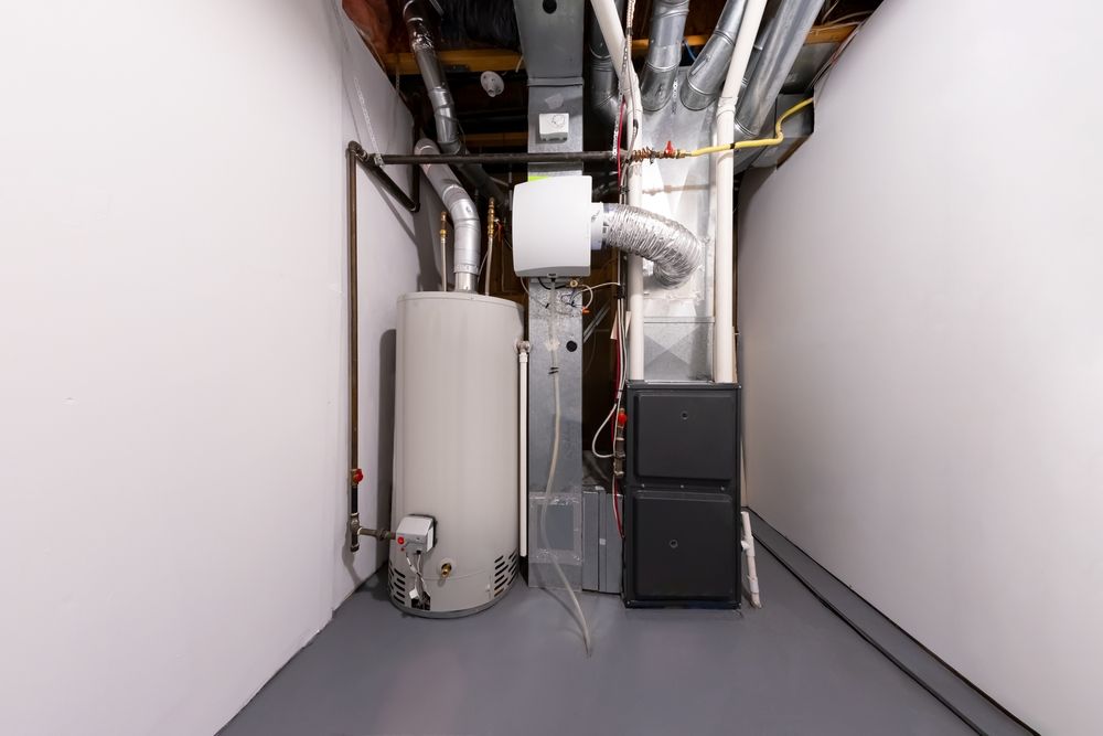 Basement mechanical room with water heater, furnace, and ductwork against white walls and gray floor.