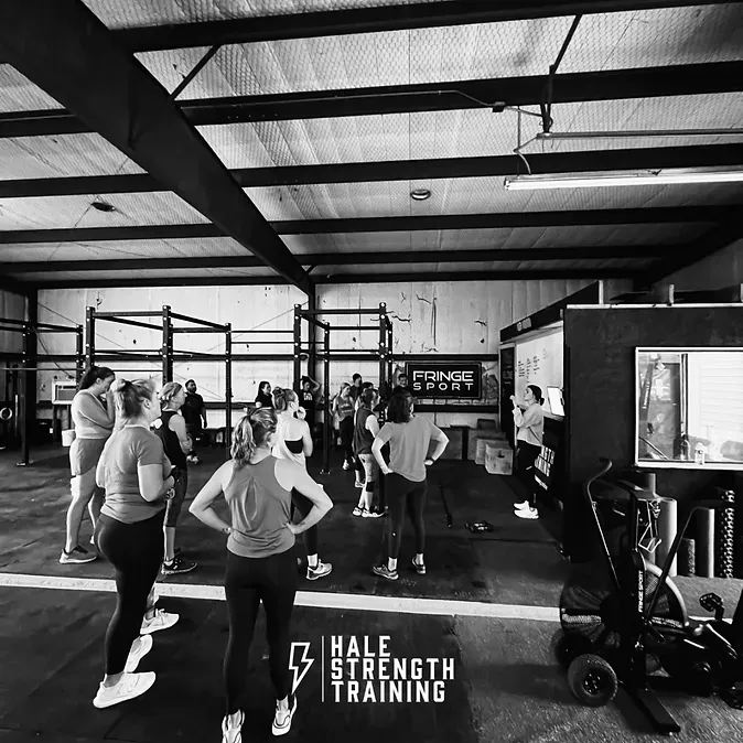 A group of people are standing in a gym.