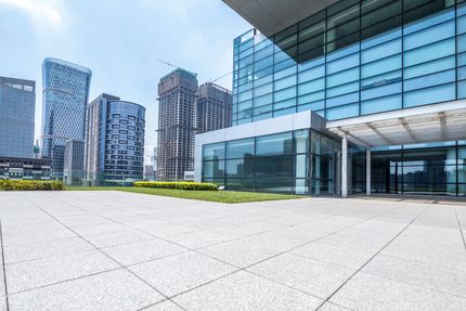 A large building with a lot of windows is in the middle of a city.