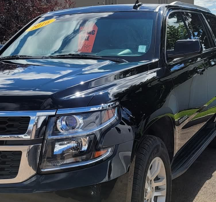 Person applying liquid detailing product to car paint with a microfiber cloth; black gloves.