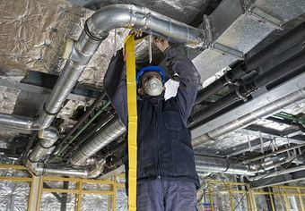 Image of person repairing AC vent