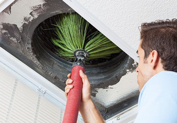 A person cleaning an air duct