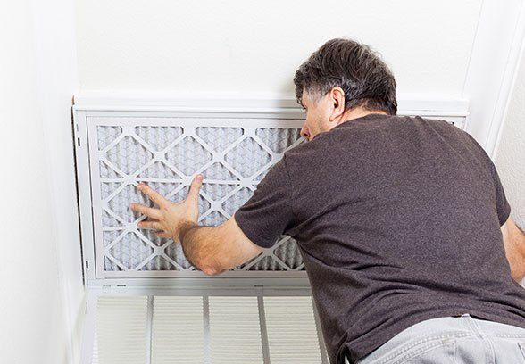 A person replacing an air filter
