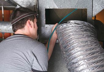 Image of a person cleaning air ducts