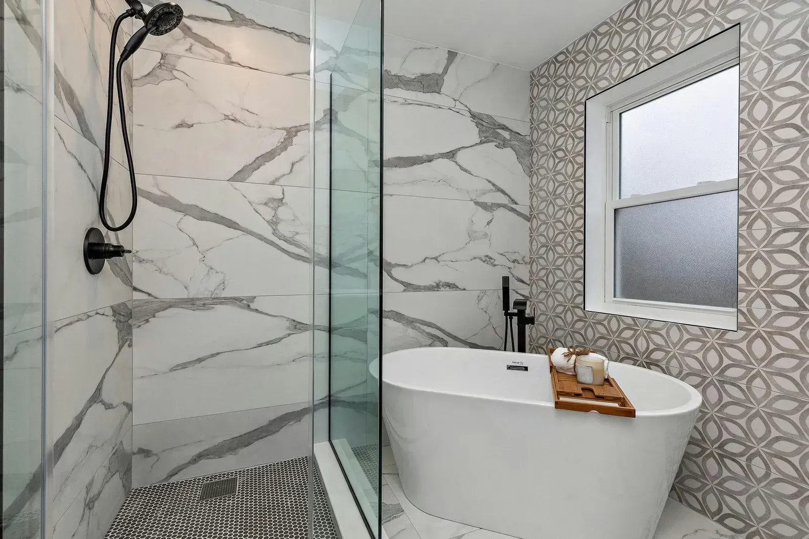 Bathroom with a glass shower, white soaking tub, patterned wall tile, and window.