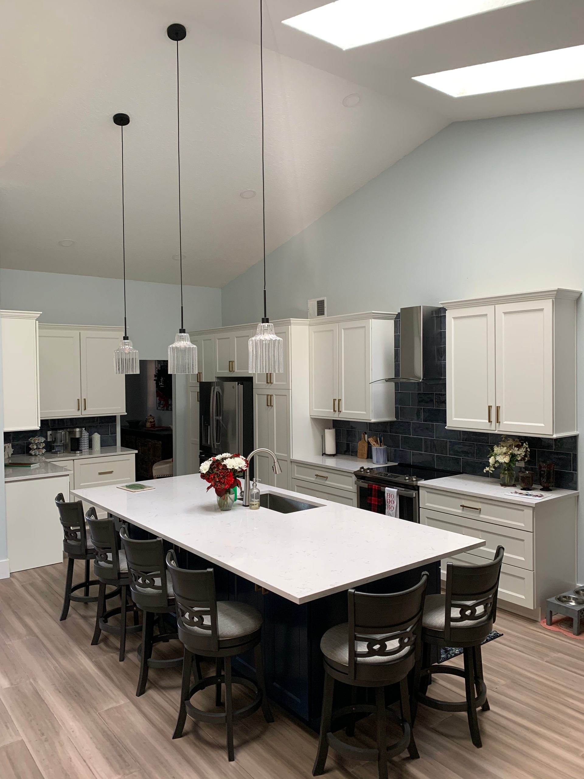 A kitchen with stainless steel appliances and gray cabinets.