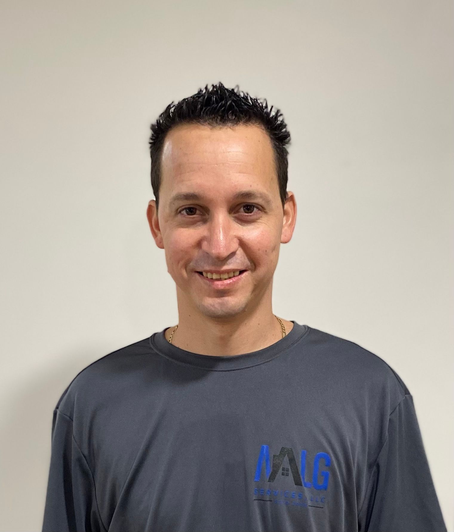 A man wearing a gray t-shirt is smiling for the camera.