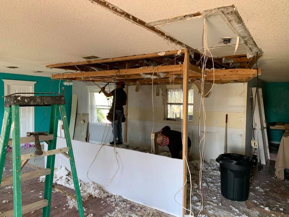 A man is working on the ceiling of a house.
