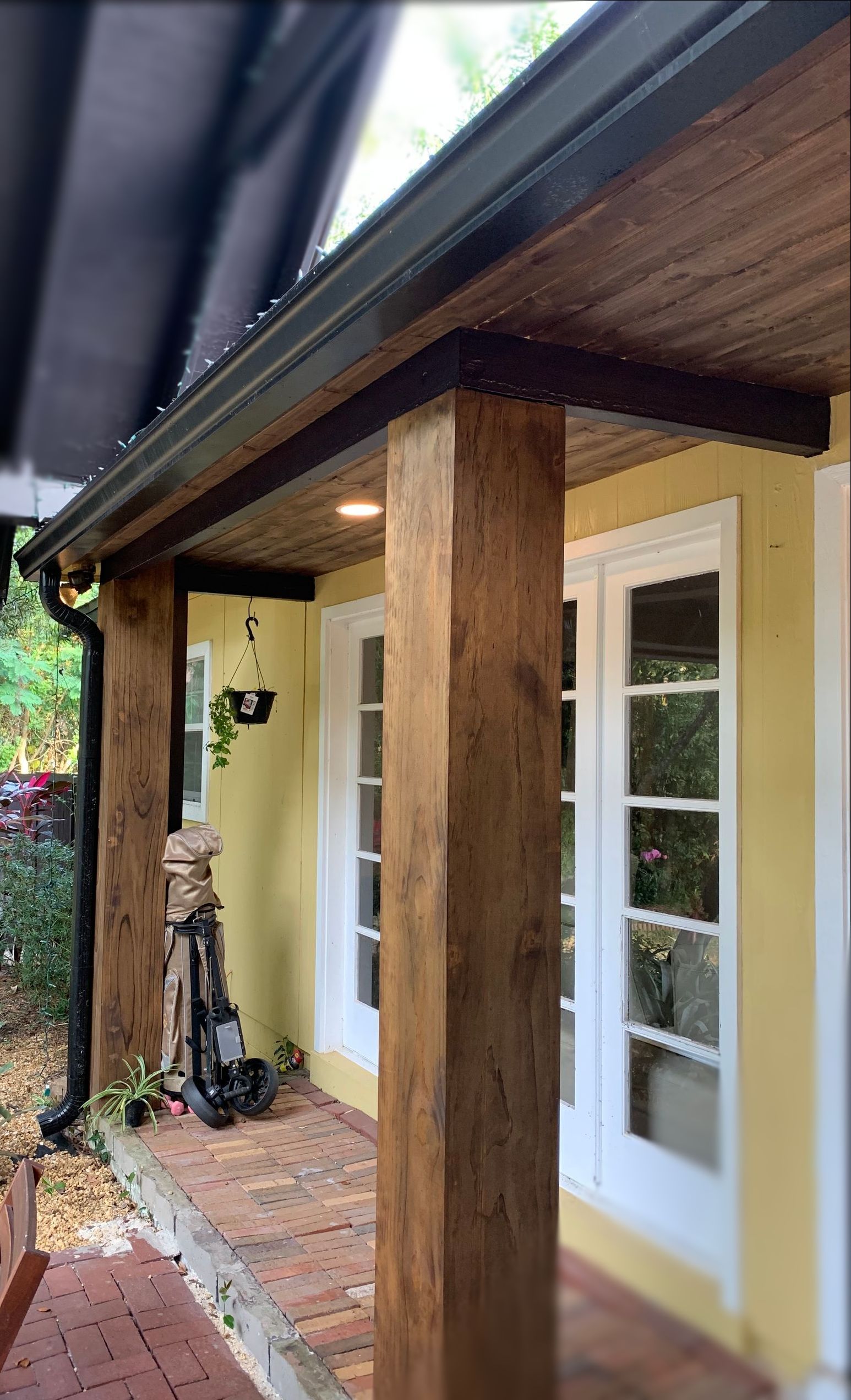 A porch with a wooden pillar and a vacuum cleaner on it.