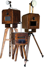Zwei Vintage-Fotoautomaten aus Holz mit angebrachten Lichtern auf Stativen.