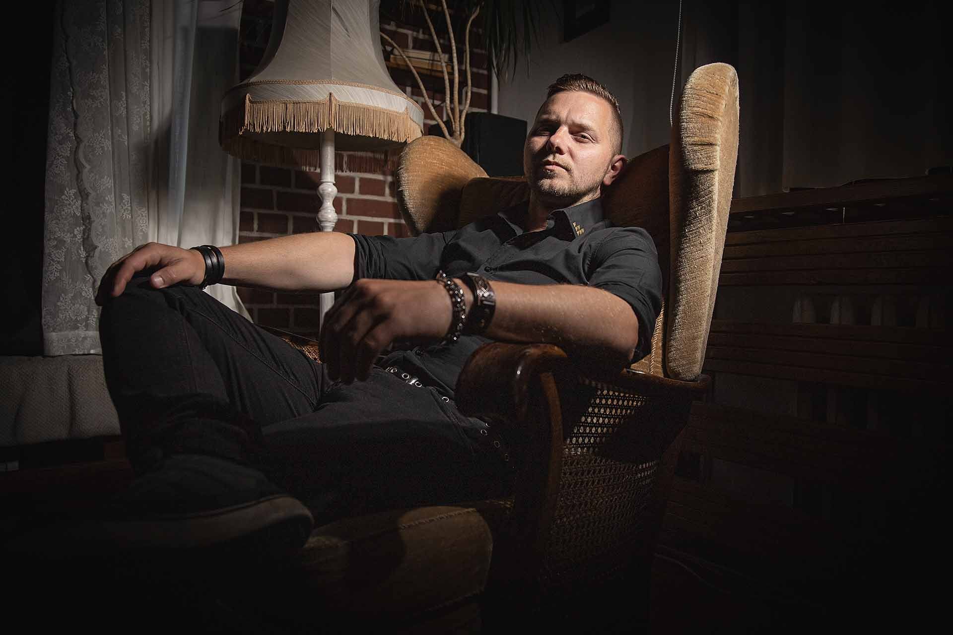 Ein Mann sitzt mit hochgelegten Füßen in einem Schaukelstuhl.