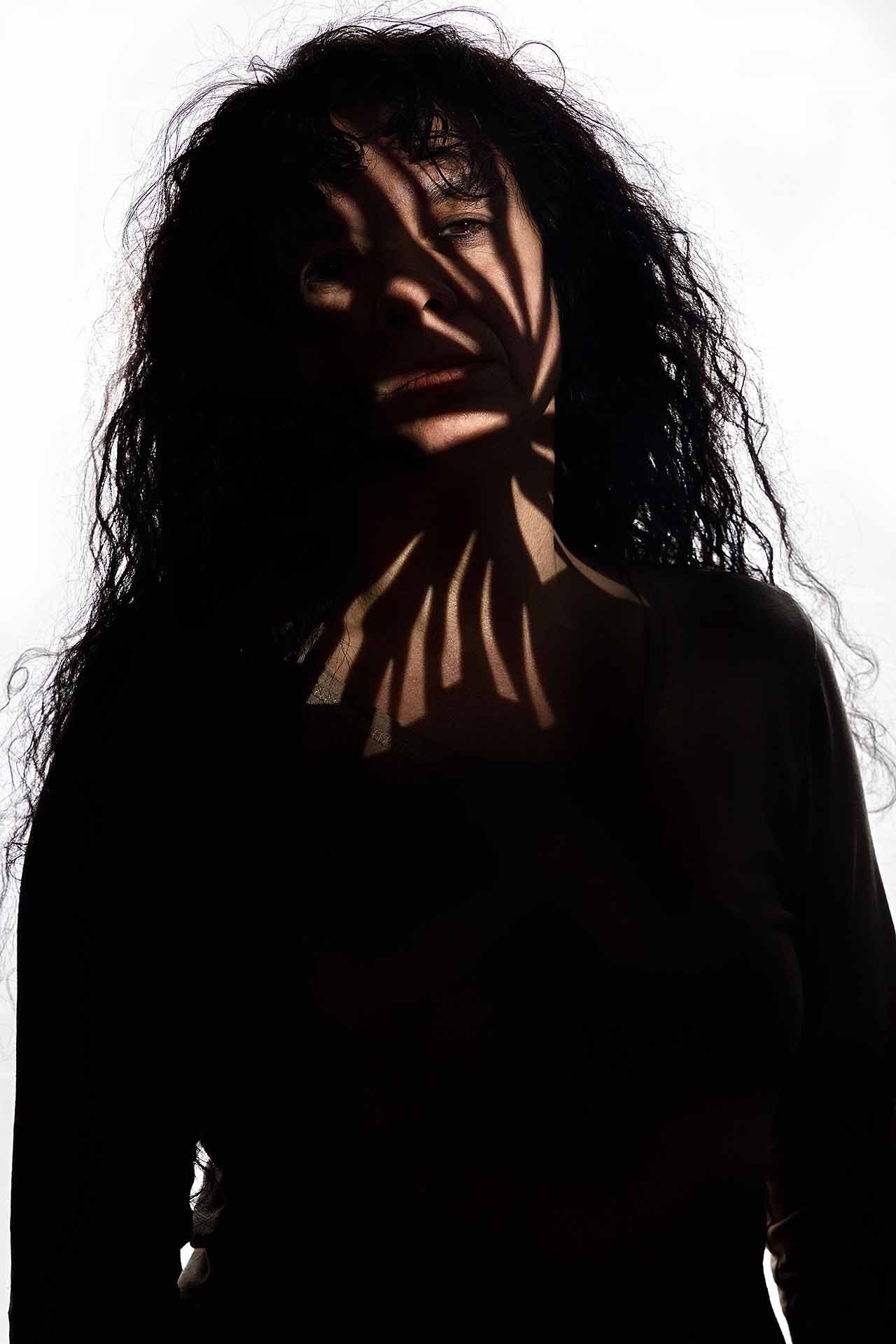 Die Silhouette einer Frau mit einem Schatten im Gesicht.