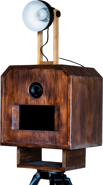 Fotoautomat aus Holz mit angebrachtem Licht, auf einem Stativ montiert.