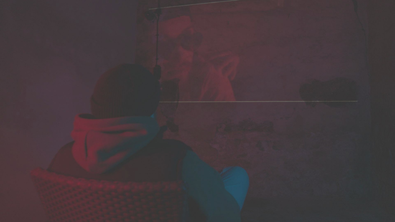 Ein verschwommenes Bild einer Person, die in einem dunklen Raum sitzt.