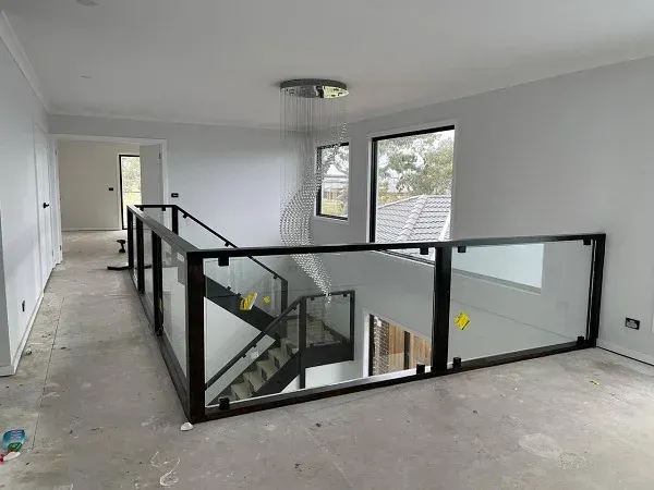 An empty room with a staircase and a glass railing.
