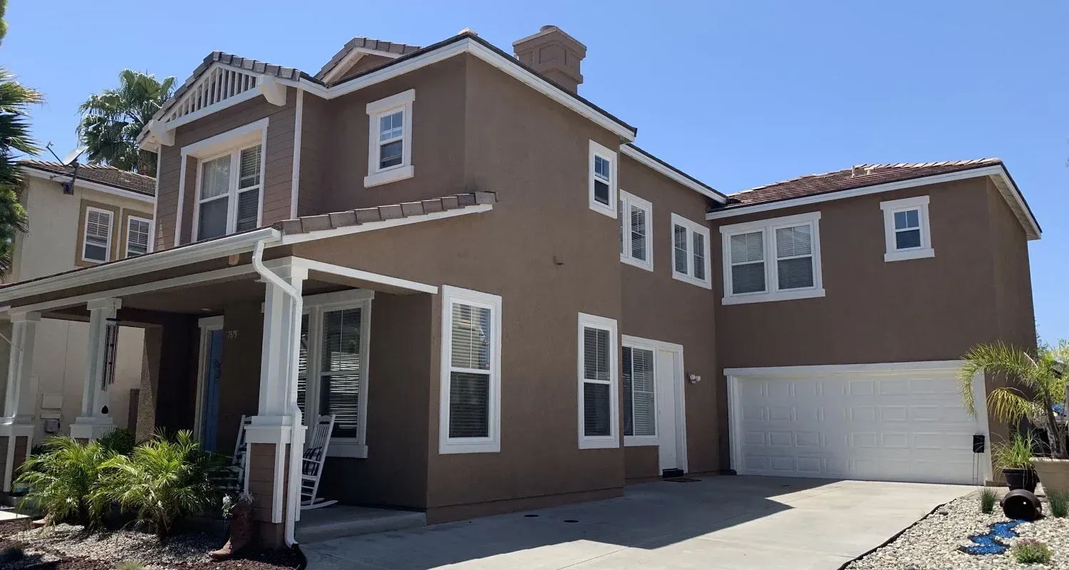 A large brown house with white trim and a white garage door