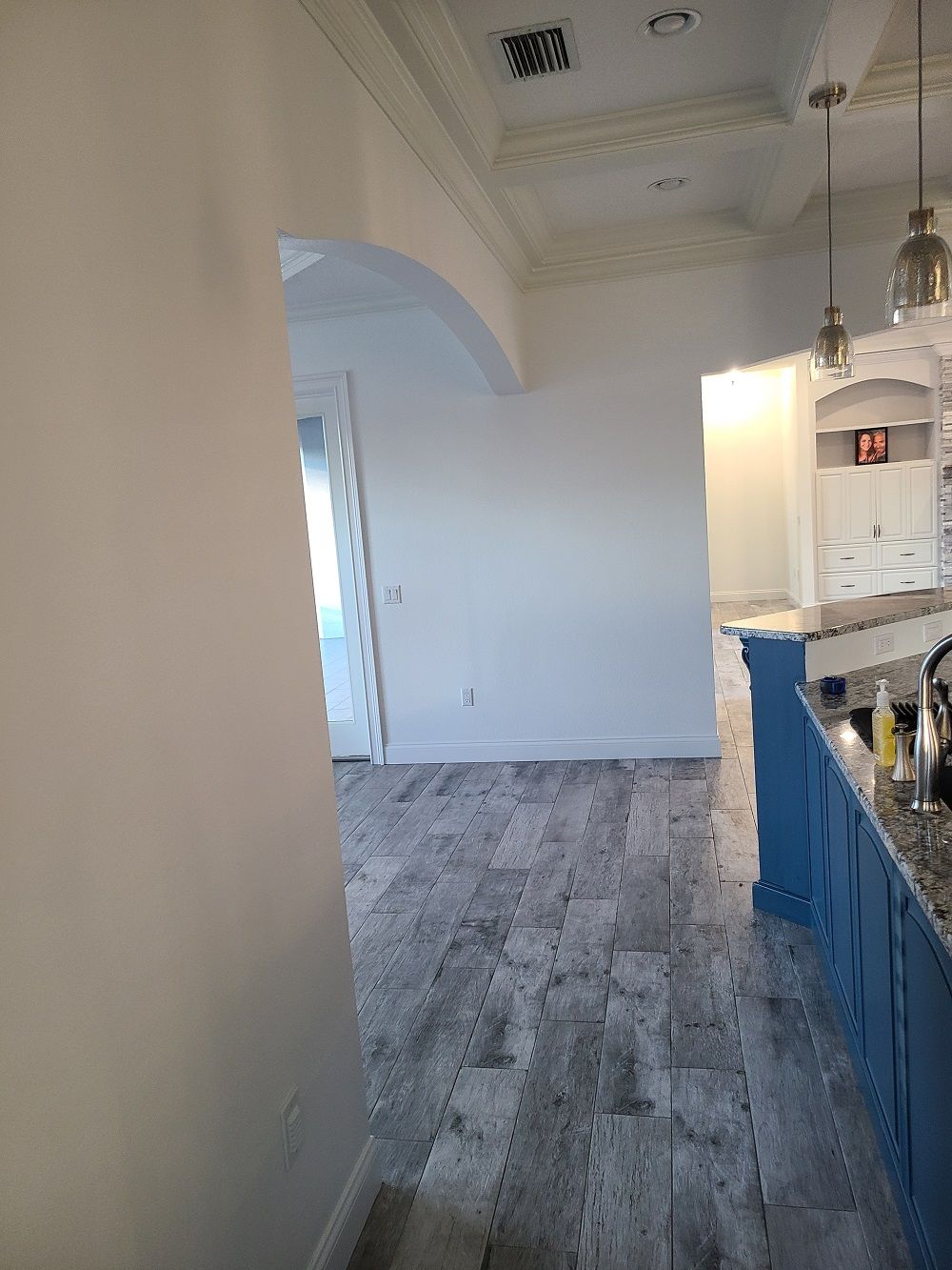 A kitchen with a wooden floor and blue cabinets.
