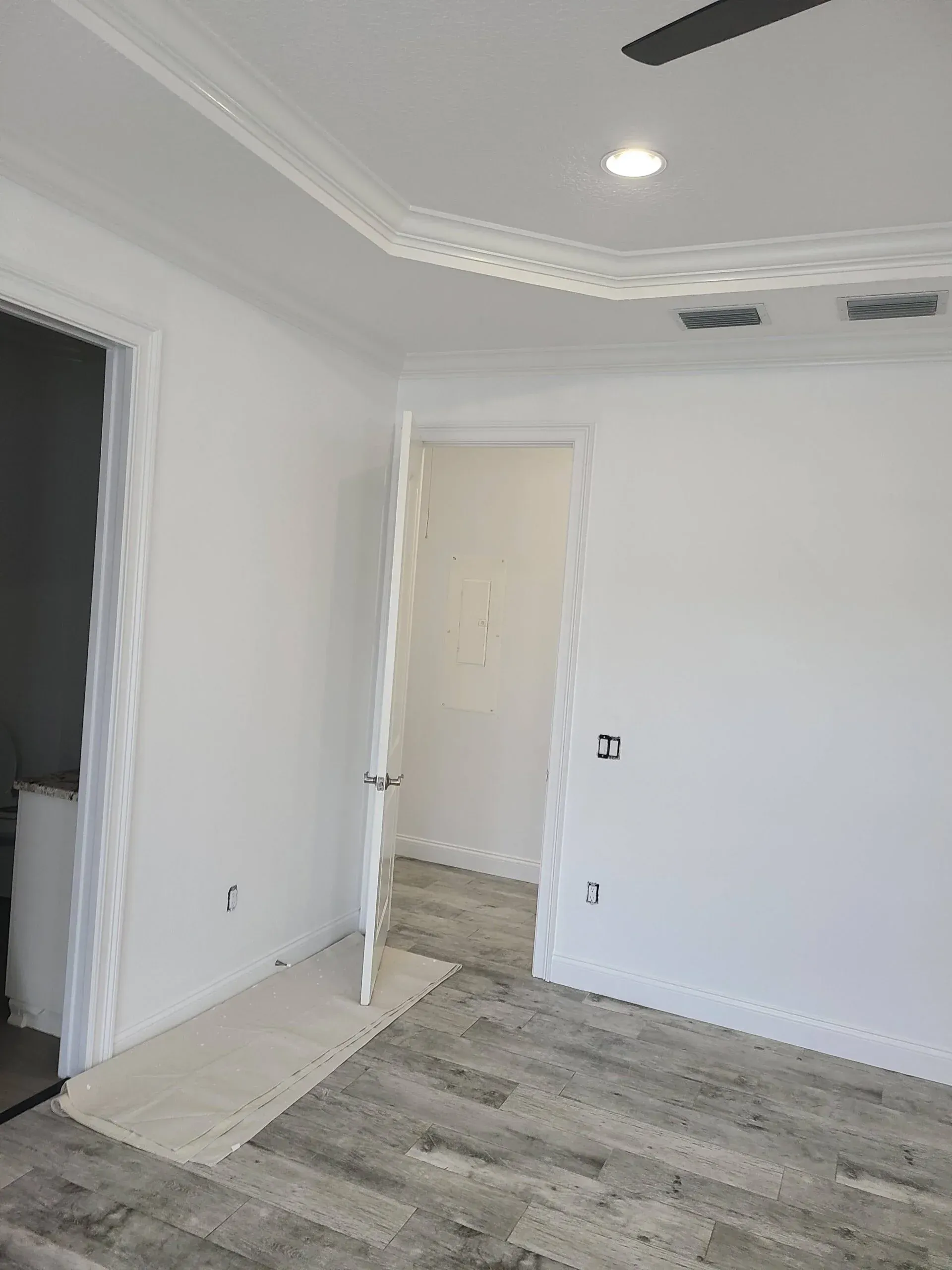 There is a ceiling fan in the corner of the room.