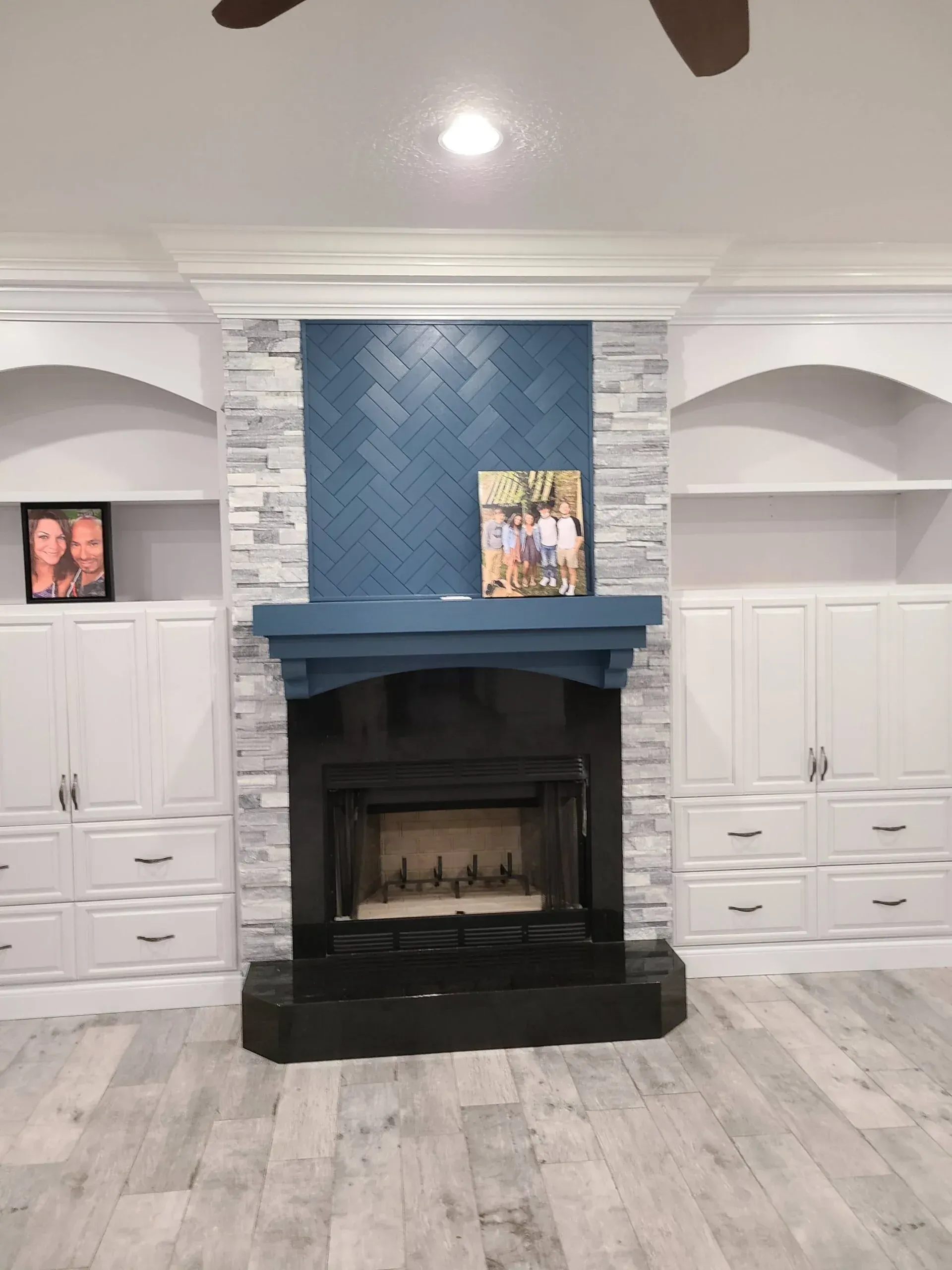A living room with a fireplace and a ceiling fan