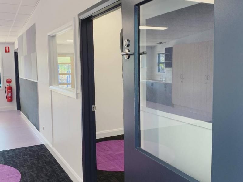 A hallway with a blue door and a purple rug