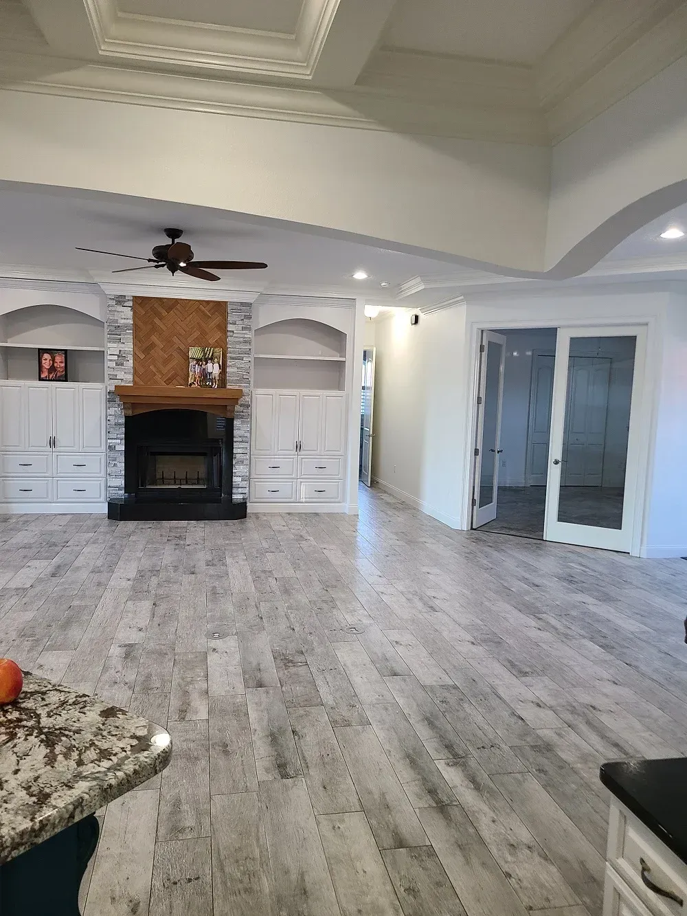 A living room with a fireplace and a ceiling fan.