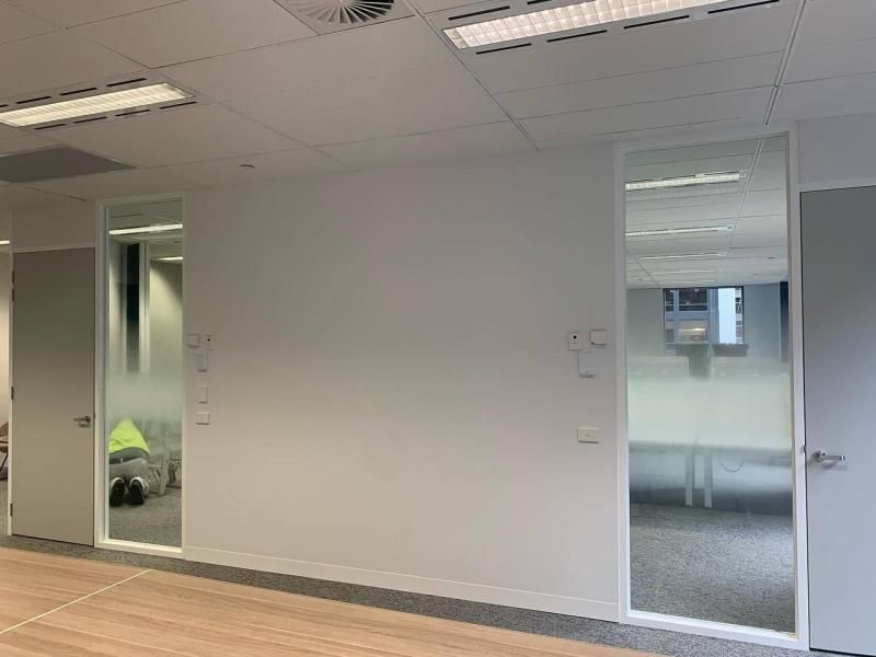 A large empty room with a wooden floor and white walls.