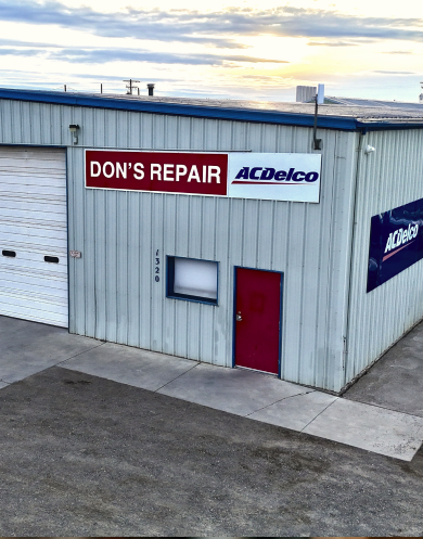 A group of six people posing for a photo in a garage. They wear matching work uniforms | Don's Repair