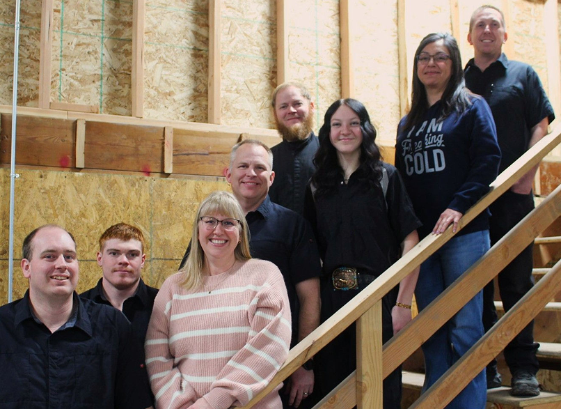 Four people stand outside a building with the number 1320 on it. They smile | Don's Repair